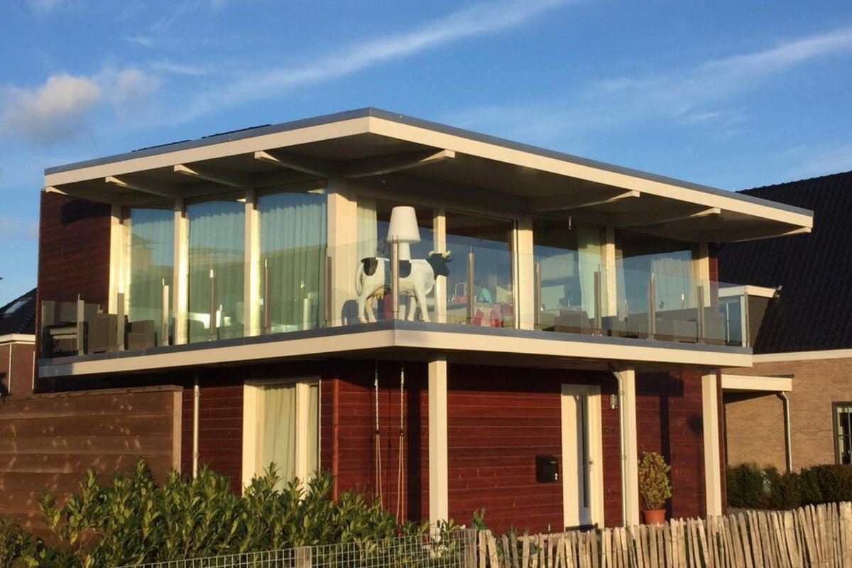 Woning uit 2017 in Alkmaar met een glazen bovenverdieping en een koe op het balkon